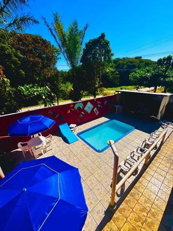 Área da piscina da Pousada Nativamar em dia ensolarado
