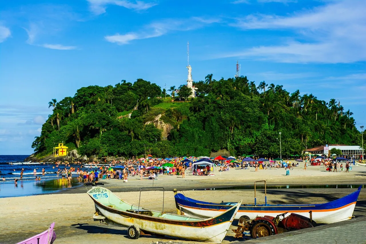 Praia de Guaratuba no litoral do Paraná com Morro do Cristo e barcos de pesca na areia